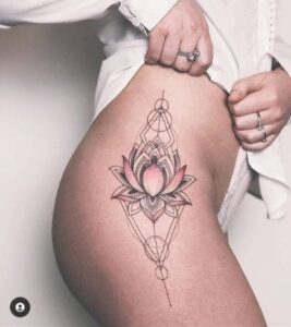 Tatuagem feminina na coxa flor de lótus delicada.