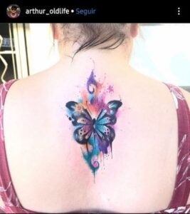 Tatuagem feminina nas costas borboleta aquarela.