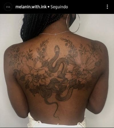 Arte floral com cobra, nas costas feminina.