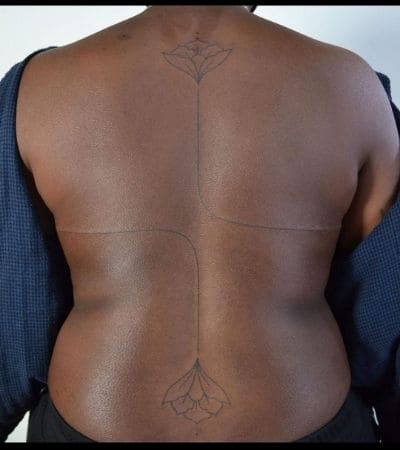 Duas flores de lótus seguidas por duas linhas, nas costas de uma mulher.