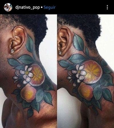 Tatuagem colorida no pescoço, folhas verdes e rodelas de laranja.