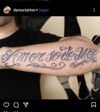 Lettering tatuado no braço com a frase "amor só de mãe".