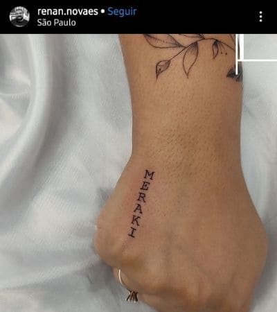 Palavra Meraki tatuada na mão em letra de forma.