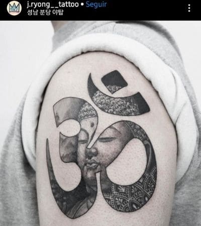 Símbolo de OM tatuado no braço.