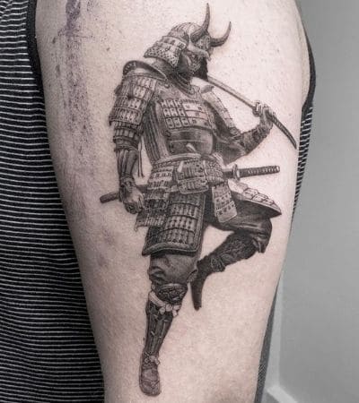 Tatuagem oriental de samurai, com espadas na mão, arte em preto e cinza.