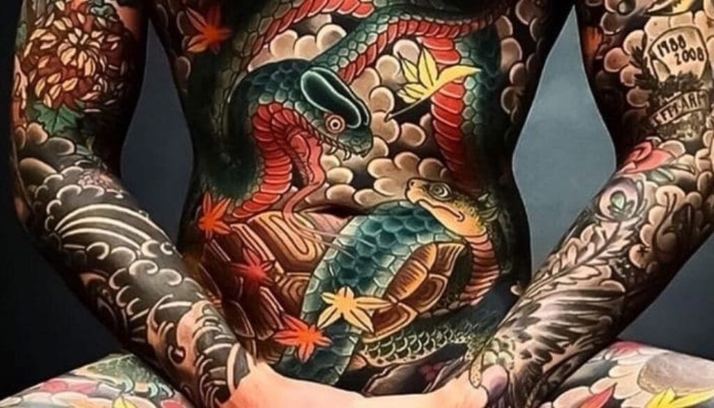 Tatuagem oriental colorida, cobrindo todo o corpo com cobras e outros elementos da cultura oriental.